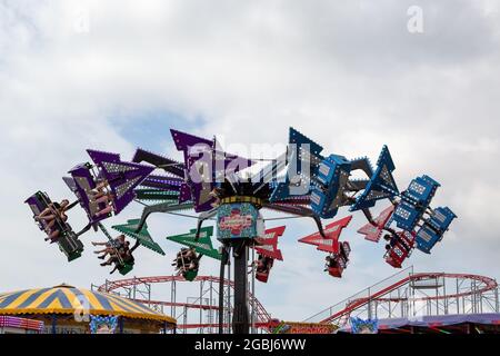 08-04-2021 Portsmouth, Hampshire, Großbritannien im Sommer reiten Menschen auf einem Messegelände am Clarence Pier, Southsea Stockfoto