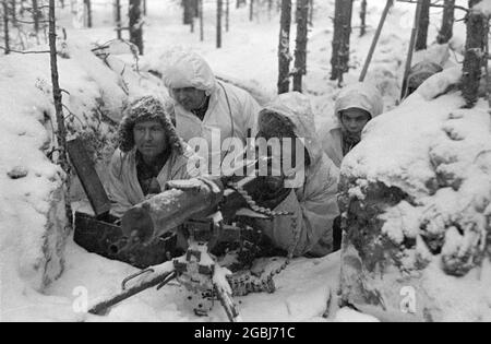 IN DER NÄHE von LEMETTI, FINNLAND - 21. Februar 1940 - EIN finnisches Maschinengewehr Maxim M-32-33 brütet während des Winterkrieges zwischen Finlan 100 Meter von sowjetischen Truppen entfernt Stockfoto