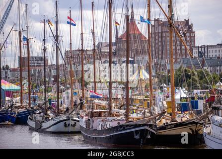 Rostock, Deutschland. August 2021. Segelboote und traditionelle Schiffe haben im Stadthafen festgemacht. Unter dem Motto 'optimistisch anders' startet am 5. August 2021 die 30. Auflage der Hanse Sail. Insgesamt haben sich 108 Schiffe aus fünf Nationen angemeldet. Quelle: Jens BŸttner/dpa-Zentralbild/dpa/Alamy Live News Stockfoto