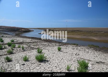 Die Gezeiten sind an der Küste der Mersey-Mündung und zeigen freiliegende Sandbänke, Seevögel, den Fluss-Alt-Nebenfluss unter blauem Himmel und das Sonnenlicht im Sommer. Stockfoto