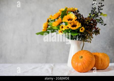 Herbstkomposition aus Kürbissen und einem Bouquet von Sonnenblumen. Speicherplatz kopieren. Stockfoto