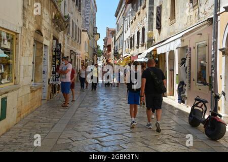 Porec, Kroatien - 10. Juli 2021. Eine Straße voller Geschäfte und Touristen in der historischen mittelalterlichen Küstenstadt Porec in Istrien, Kroatien Stockfoto