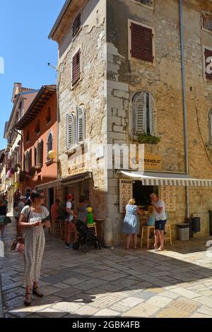 Porec, Kroatien - 10. Juli 2021. Eine Straße voller Geschäfte, Restaurants und Touristen in der historischen mittelalterlichen Küstenstadt Porec in Istrien, Kroatien Stockfoto