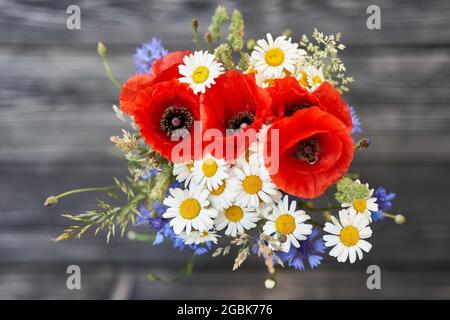 Strauß Strauß wilden Blumen Kamille Mohn Kornblume Roggen hölzernen Hintergrund Stockfoto