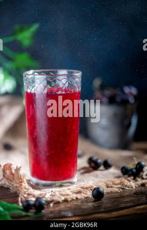 Der Fruchtsaft der Beeren im durchsichtigen Glas. Johannisbeere, Stachelbeere. Gesundes Getränk Stockfoto