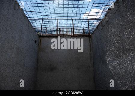 Blick auf den blauen Himmel durch die Gitter der Gefängniszelle Stockfoto