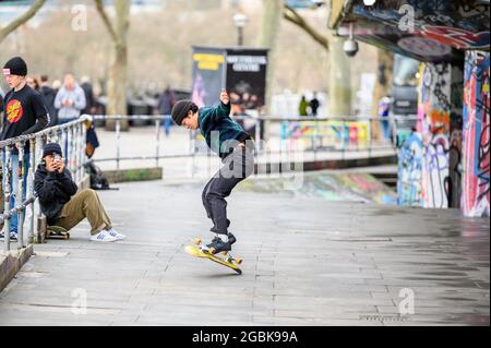 LONDON - 10. MÄRZ 2020: Eine Gruppe von Freunden übt Skateboarding in einem Skatepark am Südufer der Themse, London Stockfoto