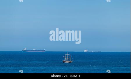 Firth of Forth, Schottland, Großbritannien, 4. August 2021. Tall Shop Pelican of London am Bass Rock: Der Tall Ship Square Rigger der Klasse A ist auf einer Reise um die britische Küste unterwegs. Das Schiff befindet sich auf der letzten Etappe seiner Tour um Großbritannien. Im Bild: Das Schiff ist vor Frachtschiffen in der Nordsee am fernen Horizont zu sehen Stockfoto