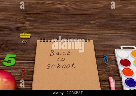 Schulbedarf, Bürobedarf auf dunklem Holz. Stockfoto