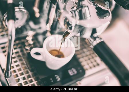 Espresso-Maschine in der Café-Bar Barista macht Single Shot Lungo. Nahaufnahme des Bechers auf der Waage Stockfoto