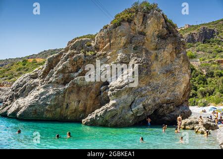 Panoramablick auf Foneas Strand überfüllt mit Touristen und Schwimmern. Der felsige Strand befindet sich in der Küstenregion Mani in der Nähe des Dorfes Kardamyli in M Stockfoto