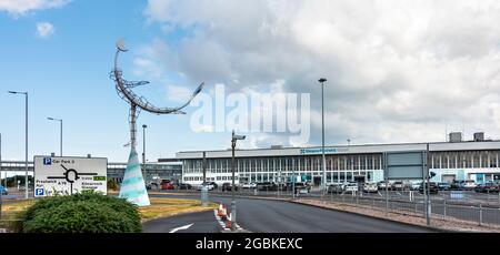 Außenansicht und Eingang zum Flughafen Glasgow Prestwick, Schottland, mit der Statue Celestial Navigator (1997) von Carole Grey. Schild mit Straßenanweisungen. Stockfoto