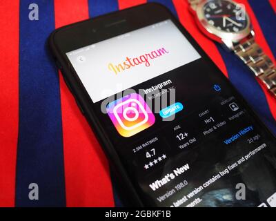 KALKUTTA, INDIEN - 02. Aug 2021: Instagram App im App Store im iPhone-Gerät auf einem Tisch geöffnet farbenfrohe Hintergrundfläche mit airpods pro. Horizontal Stockfoto