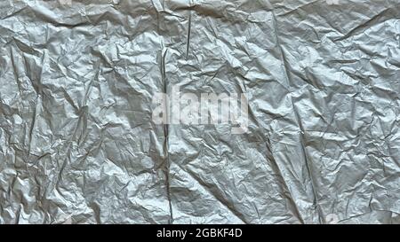 Zerknitterte Plastiktüte Textur, graues faltengebrilltes Kunststoffblatt, abstrakte Formen für Hintergrund. Stockfoto