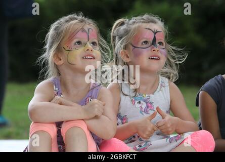 London, Großbritannien, 4. August 2021. Die eineiigen Zwillinge Lily & Scarlet Thorpe genießen Aktivitäten auf dem Spielplatz des East Finchley's Market Place im Norden Londons, am jährlichen nationalen Spieltag Großbritanniens. Monica Wells/Alamy Live News Stockfoto