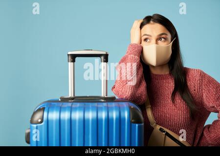 Hübsche junge Dame in Maske schaut vor dem Flug weg Stockfoto