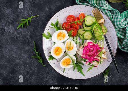 Frühstück. Gekochter Eiersalat mit Gemüse, Gurken, Tomaten und Sandwich mit Ricotta-Käse, gebratenem Hühnerfilet und roter Zwiebel. Keto/Paleo Mittagessen. Bis Stockfoto