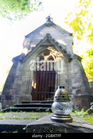 Eine kleine Lampe vor der pseudo-gotischen Kapelle mit einem Grab auf dem alten Friedhof. Stockfoto