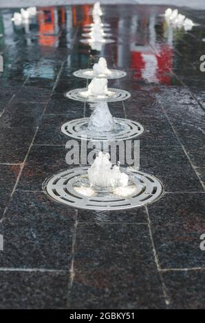 Kleine Wasserfontänen auf dem Bürgersteig am True North Square in der Innenstadt von Winnipeg, Manitoba, Kanada Stockfoto