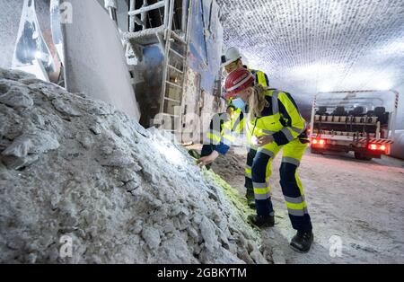 Heilbronn, Deutschland. August 2021. Die baden-württembergische Umweltministerin Thekla Walker (r, Bündnis 90/die Grünen) blickt auf einen Vorrat an Steinsalz während ihres Rundgangs durch das Salzbergwerk Heilbronn. Die Tunnel der Südwestdeutschen Salzwerke spielen unter anderem bei der Lagerung gefährlicher Abfälle eine wichtige Rolle. Quelle: Bernd Weißbrod/dpa/Alamy Live News Stockfoto
