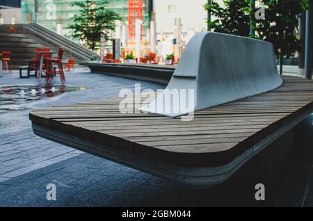 Lange kurvige Holzbank am treu North Square in der Innenstadt von Winnipeg, Manitoba, Kanada Stockfoto