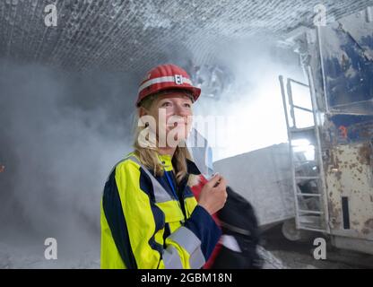 Heilbronn, Deutschland. August 2021. Die baden-württembergische Umweltministerin Thekla Walker (l, Bündnis 90/die Grünen) untersucht während ihres Rundgangs durch das Salzbergwerk Heilbronn den Bergbau in einem Stollen. Die Tunnel der Südwestdeutschen Salzwerke spielen unter anderem bei der Lagerung gefährlicher Abfälle eine wichtige Rolle. Quelle: Bernd Weißbrod/dpa/Alamy Live News Stockfoto
