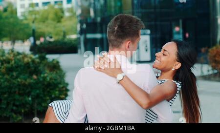 Junger Mann, der seine Herzliebe in den Händen hält und sich im Freien herumdreht. Sie haben das Datum an einem Sommerabend. Stockfoto