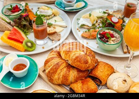 High-Angle-Shot-Croissants, verschiedene Gebäckstücke mit Orangensaft und andere leckere Snacks Stockfoto