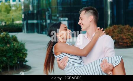 Junger Mann, der seine Herzliebe in den Händen hält und sich im Freien herumdreht. Sie haben das Datum an einem Sommerabend. Stockfoto