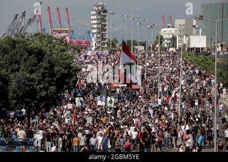 Beirut, Libanon. August 2021. Die Menschen nehmen an einem marsch in Richtung des Hafens von Beirut Teil, um an einer Zeremonie anlässlich des 1. Jahrestages der massiven Explosion des Hafens von Beirut im August 2020 teilzunehmen. Am 04. August 2020 ging eine große Menge Ammoniumnitrat, die im Hafen von Beirut gelagert wurde, los, wobei mindestens 218 Menschen getötet und 7,500 weitere verletzt wurden. Quelle: Marwan Naamani/dpa/Alamy Live News Stockfoto