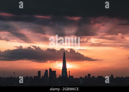 London, Großbritannien. August 2021. UK Wetter: Dramatische Abendstrahlen strahlen von einer untergehenden Sonne hinter dem Shard Wolkenkratzer Gebäude. Kredit: Guy Corbishley/Alamy Live Nachrichten Stockfoto