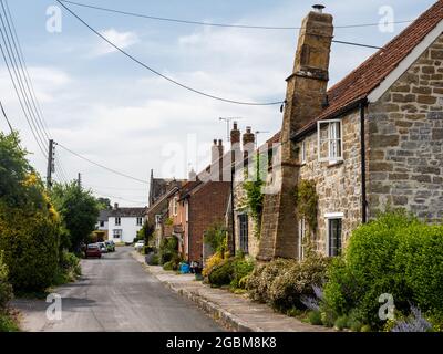 Traditionelle Stein- und Ziegelhütten säumen die Church Street im Dorf Kingsbury Episcopi in South Somerset. Stockfoto