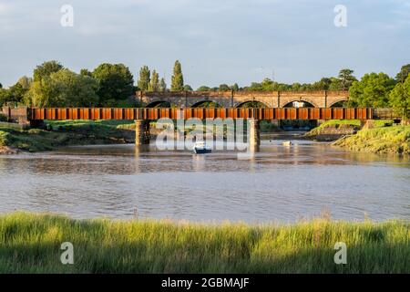 Der Fluss Trym fließt unter Viadukten der A4 Portway Road und der Severn Beach Line Bahn in die Mündung des Avon at Sea Mills in Bristol. Stockfoto