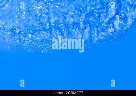 Nahaufnahme der Serumtextur. Klarer blauer flüssiger Gel-Hintergrund. Produktprobe für transparente Schönheitspflege. Kosmetische klare flüssige Creme verschmiert. Transparent Stockfoto
