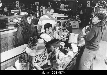 Austin Texas USA, um 1990: Hispanische Familie an der Kasse des örtlichen Reformhauses Whole Foods. MR es-0437 Farbe erhältlich. ©Bob Daemmrich Stockfoto