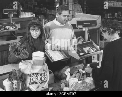 Austin Texas USA, um 1990: Hispanische Familie an der Kasse des örtlichen Reformhauses Whole Foods. MR es-0437 Farbe erhältlich. ©Bob Daemmrich Stockfoto