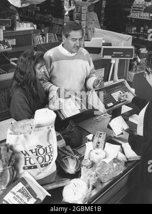 Austin Texas USA, um 1990: Hispanische Familie an der Kasse des örtlichen Reformhauses Whole Foods. MR es-0437 Farbe erhältlich. ©Bob Daemmrich Stockfoto