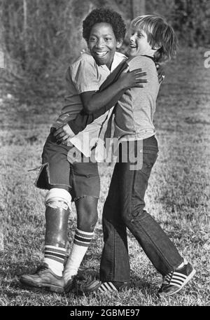 Austin, Texas, USA, um 1984: Der Junge der 4. Klasse Patrick Skeaton, der eine Spina bifida hat und in der 3. Klasse ein Bein amputiert haben musste. Die Fotogeschichte zeigt ihn während eines typischen Schultages; hier ist er in der Pause mit einem Freund in rauer Wohnung. ©Bob Daemmrich Stockfoto