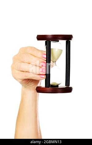 Nahaufnahme einer weiblichen Hand, die eine alte Sanduhr hält, isoliert auf Weiß Stockfoto