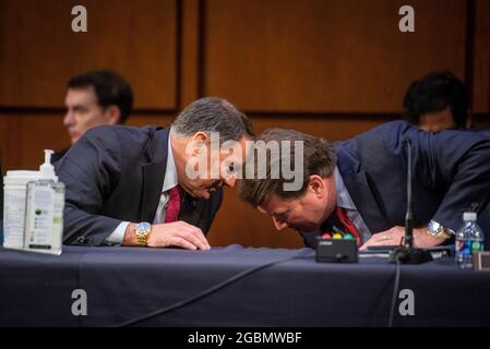 Washington, Vereinigte Staaten. August 2021. Der US-Senator Mike Rounds (Republikaner von South Dakota), links, übergibt dem US-Senator Bill Hagerty (Republikaner von Tennessee), rechts, während einer Geschäftssitzung des Senatsausschusses für Außenbeziehungen für Nominierungen und legislative Überlegungen im Hart Senate Office Building in Washington, DC, Mittwoch, 4. August 2021. Kredit: Rod Lampey/CNP/dpa/Alamy Live Nachrichten Stockfoto