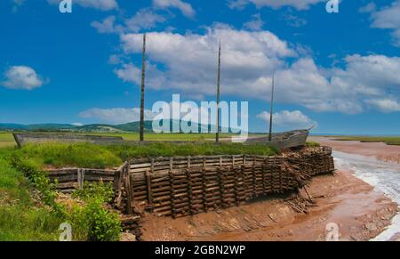 Altes Wikinger-ähnliches Holzsegelboot, das bei Ebbe in Harvey New Brunswick an der Bay of Fundy Coast, Kanada, aufgegeben wurde Stockfoto