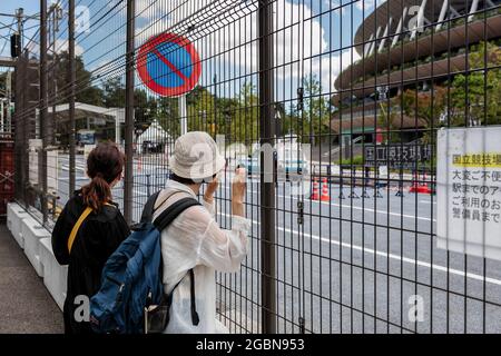Tokio, Japan. August 2021. Menschen, die am Nationalen Olympiastadion vorbeikommen und Fotos machen und darauf warten, einen Blick auf einige Athleten zu werfen. (Foto: Tanja Houwerzijl/SOPA Images/Sipa USA) Quelle: SIPA USA/Alamy Live News Stockfoto