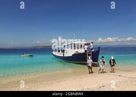 Labuan Bajo, Indonesien - Juni 30 2021: Touristen disemark von einem Boot am Ziel der Pirateninsel vor der Küste von Labuan Bajo in Flores in Stockfoto