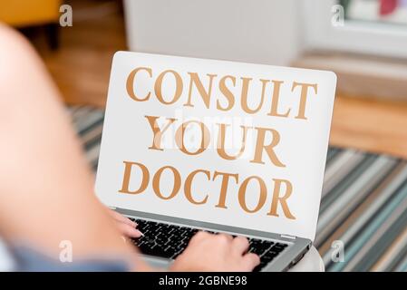 Textschild mit der Anzeige „Konsultieren Sie Ihren Arzt“. Konzeptfoto Fragen Sie einen Arzt oder eine Ärztin nach Informationen oder Rat für sprach- und Videoanrufe Stockfoto