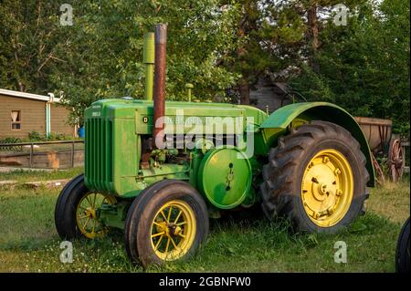 Rosebud, Alberta - 23. Juli 2021: Der alte John Deer Traktor akros aus dem Rosebud Opera House am Abend. Stockfoto