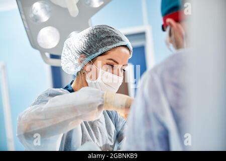 Chirurg bei der Arbeit im Operationssaal Moderne Ausstattung im Operationssaal, medizinische Produkte für die Neurochirurgie und rekonstruktive Kunststoffe. Stockfoto