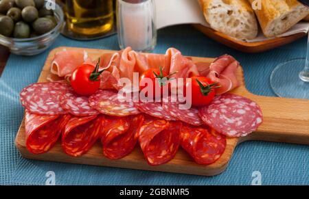 Spanische leckere Mahlzeit Würste und Jamon mit Tomaten schneiden, Nahaufnahme Stockfoto