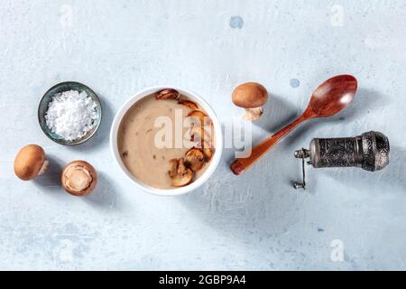 Pilzsuppe kochen. Cremini Pilze, Salz, Pfeffer, einen Holzlöffel, darüber flach lag Schuss Stockfoto