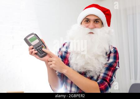 Porträt von seinem er schöne attraktive Santa halten in der Hand bankkarte digitales Terminal System Handel Handel Stockfoto