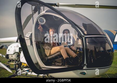 Fröhlich Tween Mädchen zeigt zum Himmel aus Hubschrauber-Cockpit Stockfoto